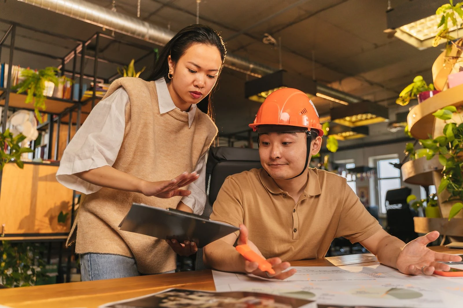 Stockfoto van een vrouw en een engineer die technische plannen bespreken
